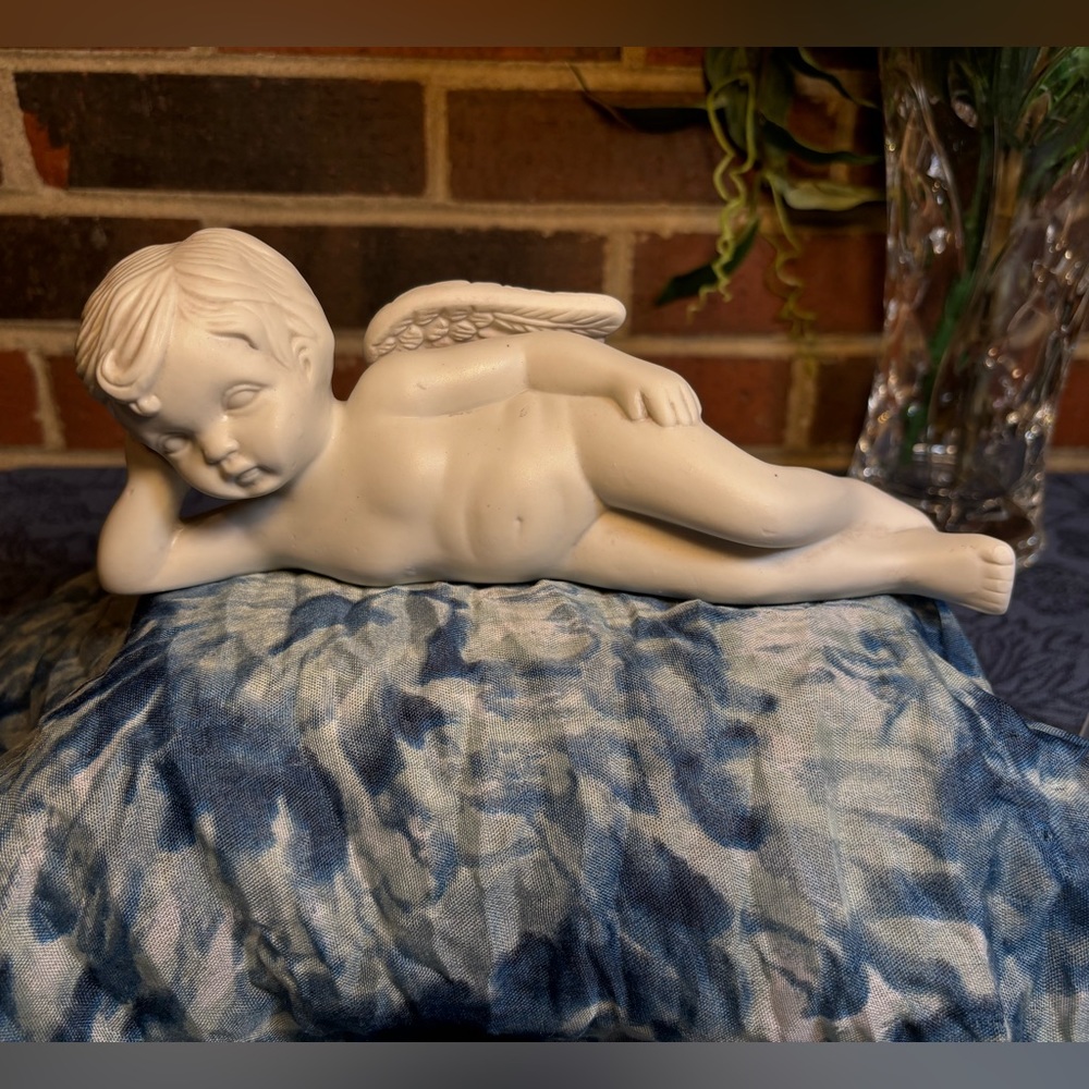 Angel Laying on side. About 9” long and a little over 3” tall. Porcelain used